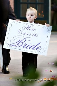 Here comes the bride sign held by ring bearer