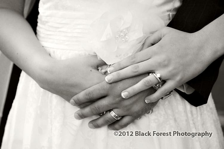 black and white close up wedding picture of the bride and groom's hands